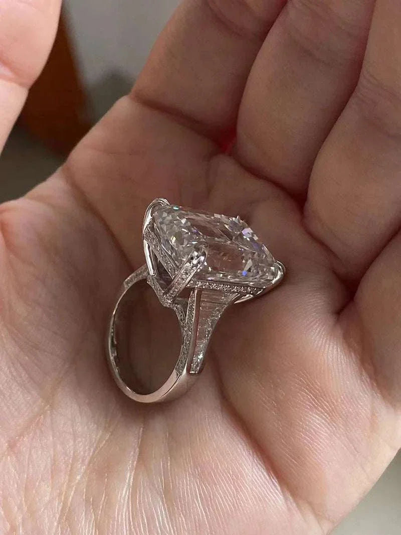 Ruif Unique Customized 20-carat emerald-cut diamond ring with intricate setting held in hand