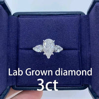 The Aurelia Sigil pear-shaped 3-carat lab-grown diamond ring with side stones in a navy blue velvet box