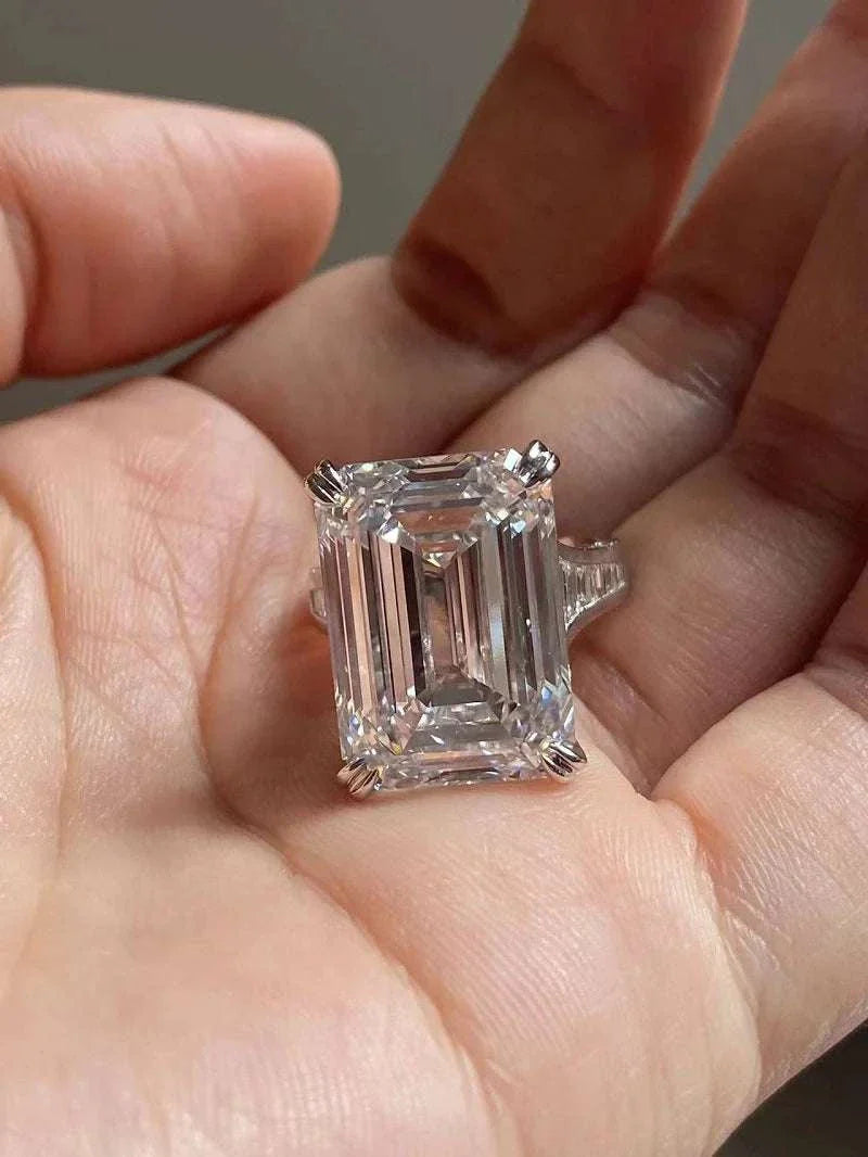 Ruif Unique Customized 20-carat emerald cut diamond ring with VS1 clarity and F color, held in hand.