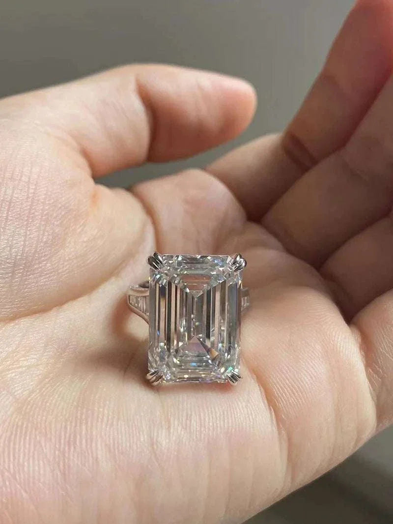 Ruif Unique Customized 20-carat emerald cut diamond ring held in hand with VS1 clarity and F color.