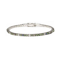 18K white gold tennis bracelet with blue sapphires, green tsavorite gemstones, and 3/8 CTTW diamonds in prong settings.