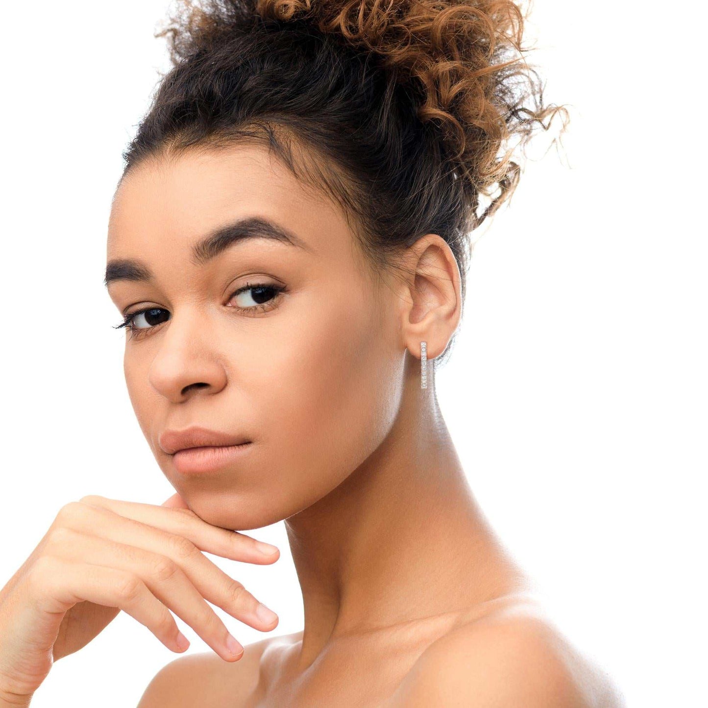 18K rose gold round bezel-set diamond hoop earrings worn by woman with curly hair