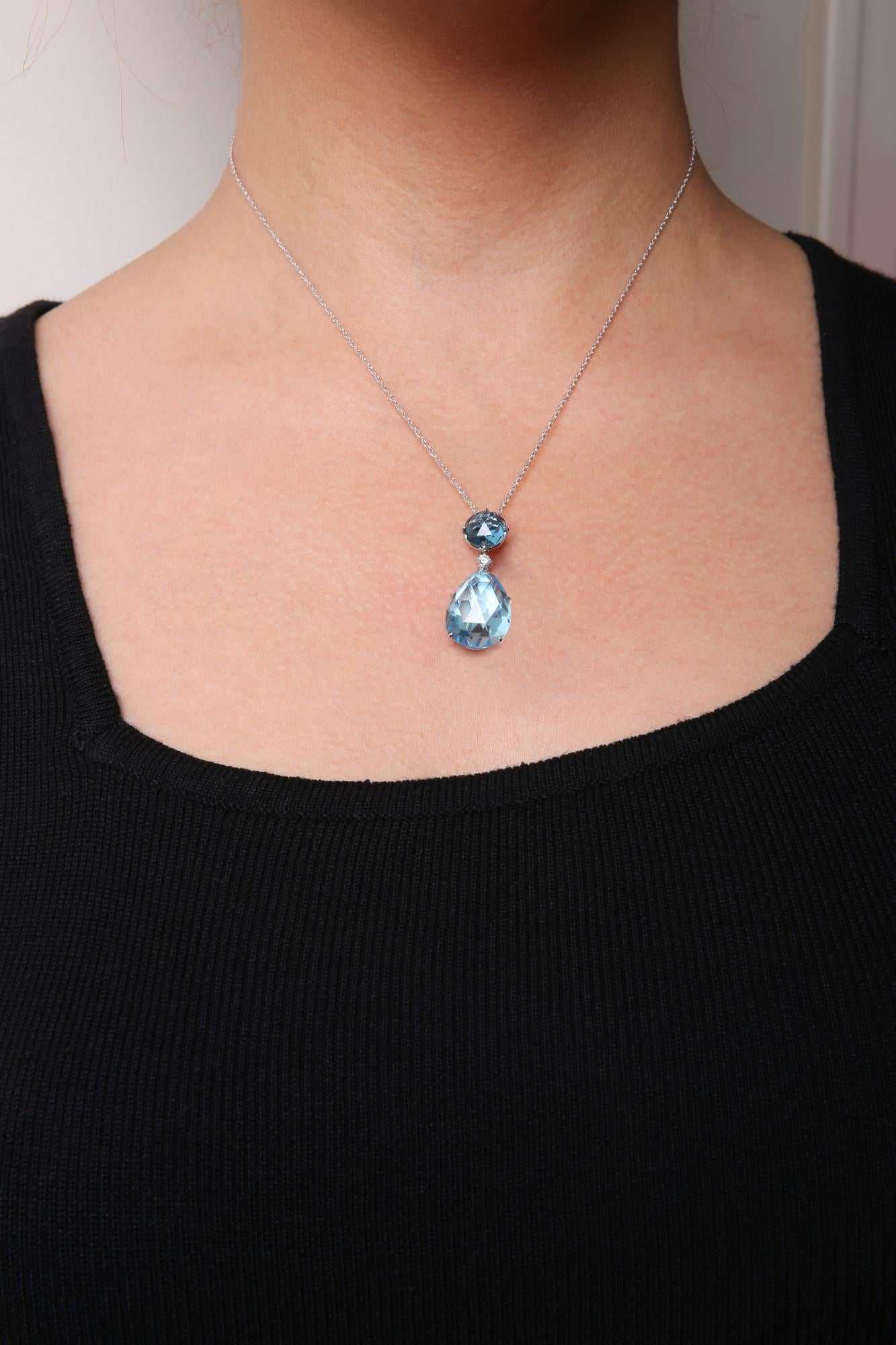 Blue Topaz and Pear Cut Sky Blue Topaz dangle drop pendant necklace on white gold chain worn on neck