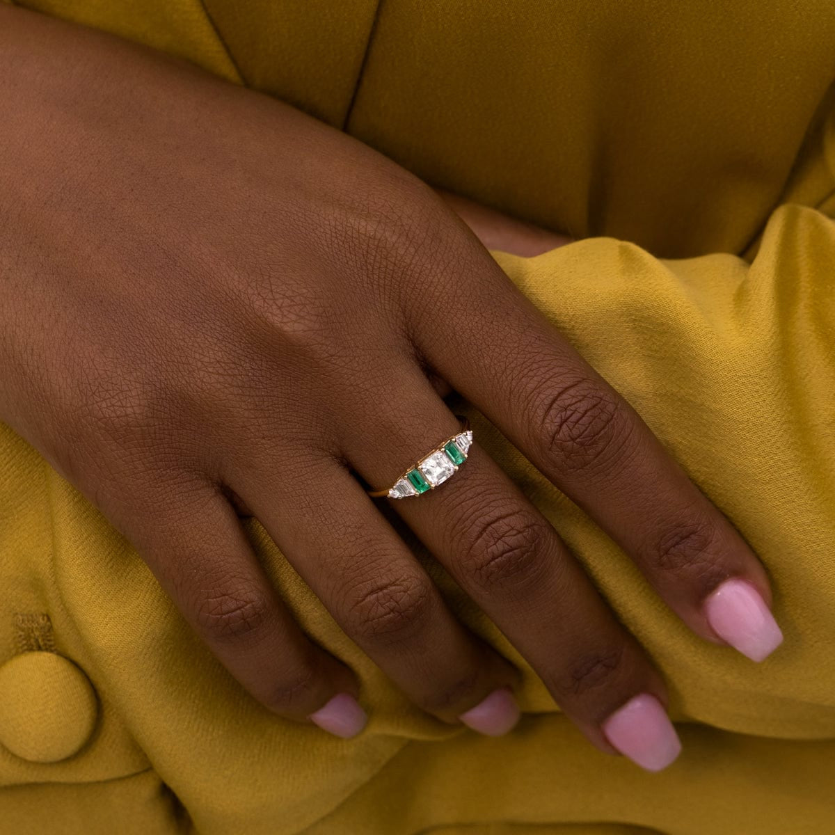 14k yellow gold Hall of Emerald Ring with natural rectangular emeralds and Asscher-cut diamond on a woman's hand