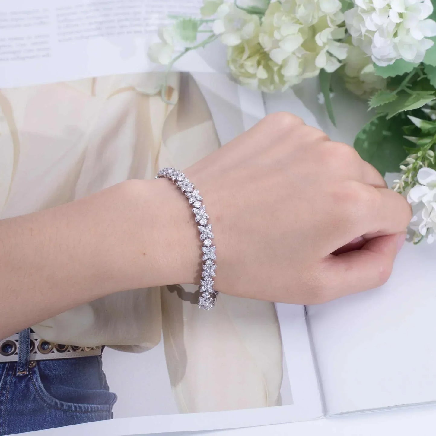 Frostforged Chain of the Titan 14k gold Cuban bracelet with lab-grown diamonds on wrist against floral background