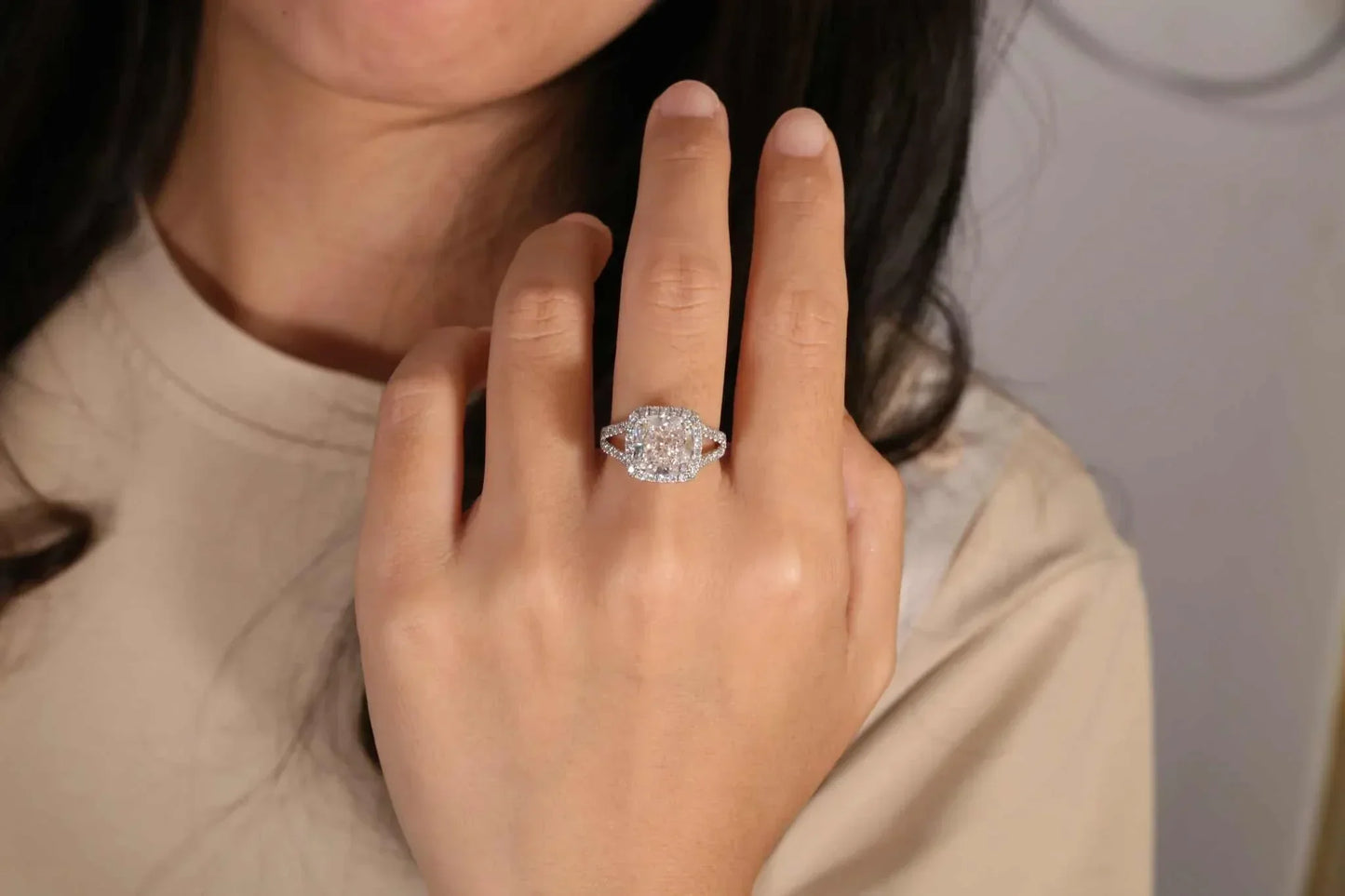 Starfire Crown of Avaloria ring featuring a 5.0ct cushion-cut diamond solitaire worn on a woman's hand.