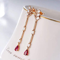 18K white gold diamond dangle earrings with pear-shaped red gemstones and rectangular diamonds