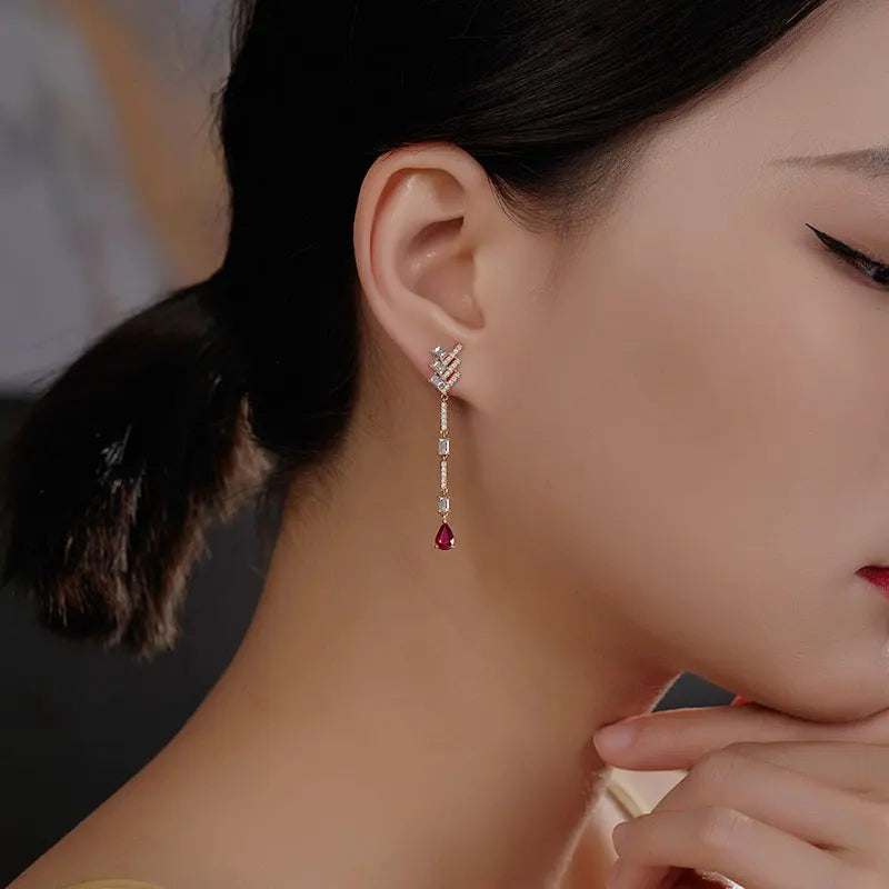 18K white gold diamond dangle earrings with white topaz and pear-shaped black onyx gemstones worn by a woman
