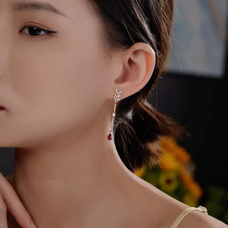 18K white gold diamond, white topaz, and pear-shaped black onyx dangle earrings worn by woman
