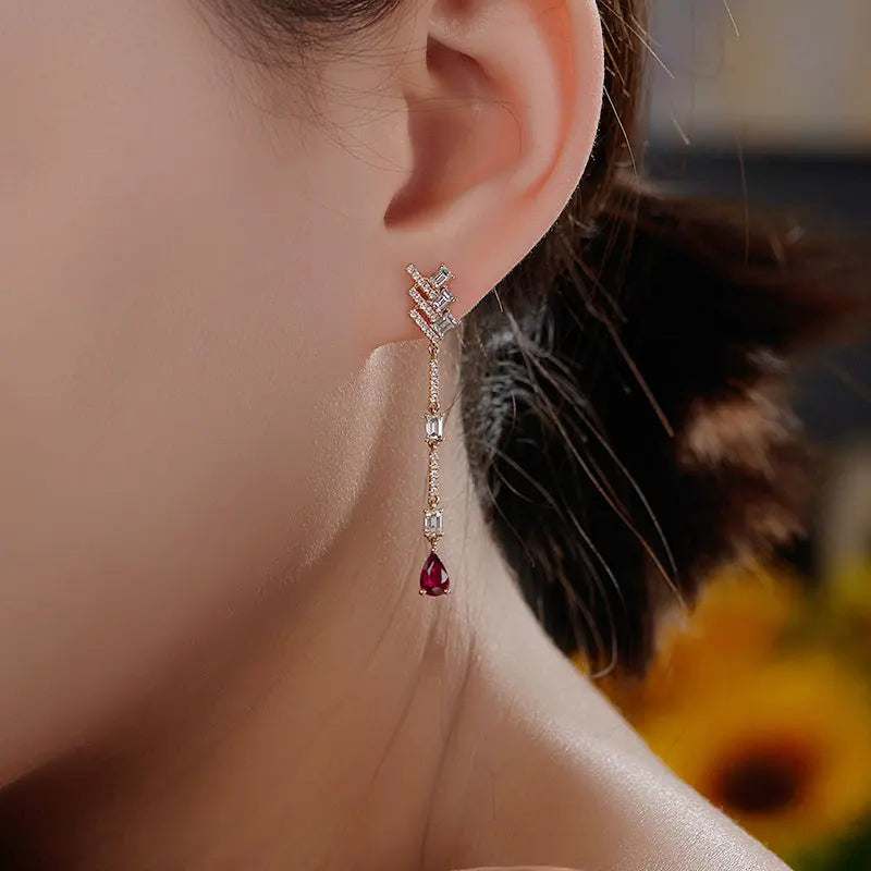 18K white gold diamond, white topaz, and pear-shaped black onyx dangle earrings worn on ear