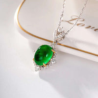 Luxury bridal jewelry featuring a genuine 18k white gold pendant with a natural emerald and diamond accents