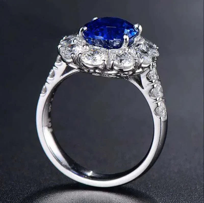 White gold ring featuring a natural blue sapphire center stone named Star of Ithil, surrounded by smaller diamonds.