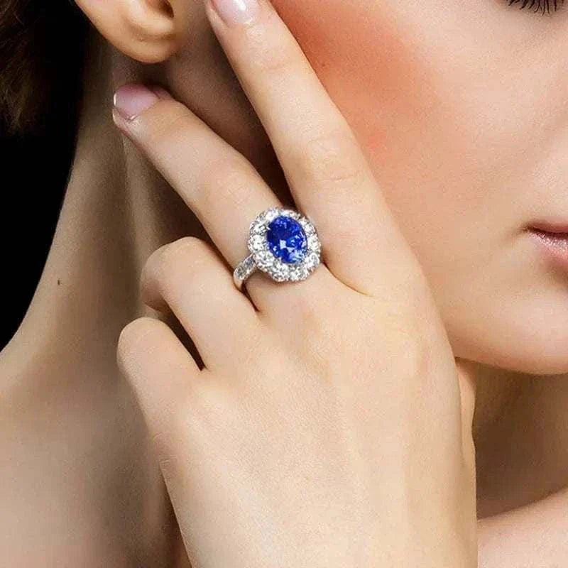 Elegant white gold ring featuring a natural blue sapphire center stone surrounded by smaller diamonds, known as the Star of Ithil ring