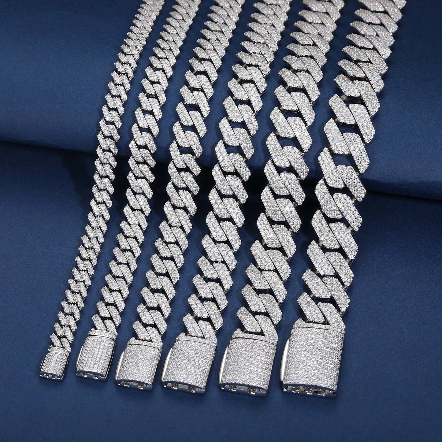 925 sterling silver Cuban link chains with VVS moissanite stones in graduated sizes on blue background