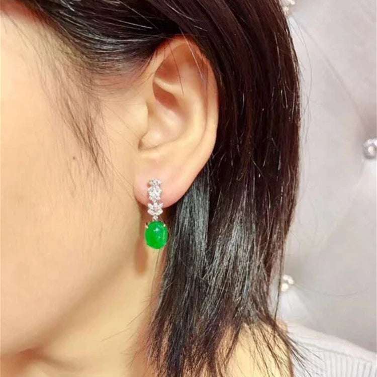 18k gold South Africa natural emerald and diamond drop earrings on woman's ear