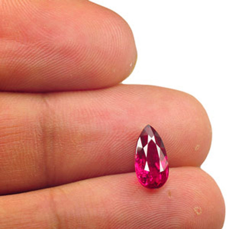 GIA certified 2.02 ct natural untreated neon purplish red pear-shaped Mozambique ruby held between fingers