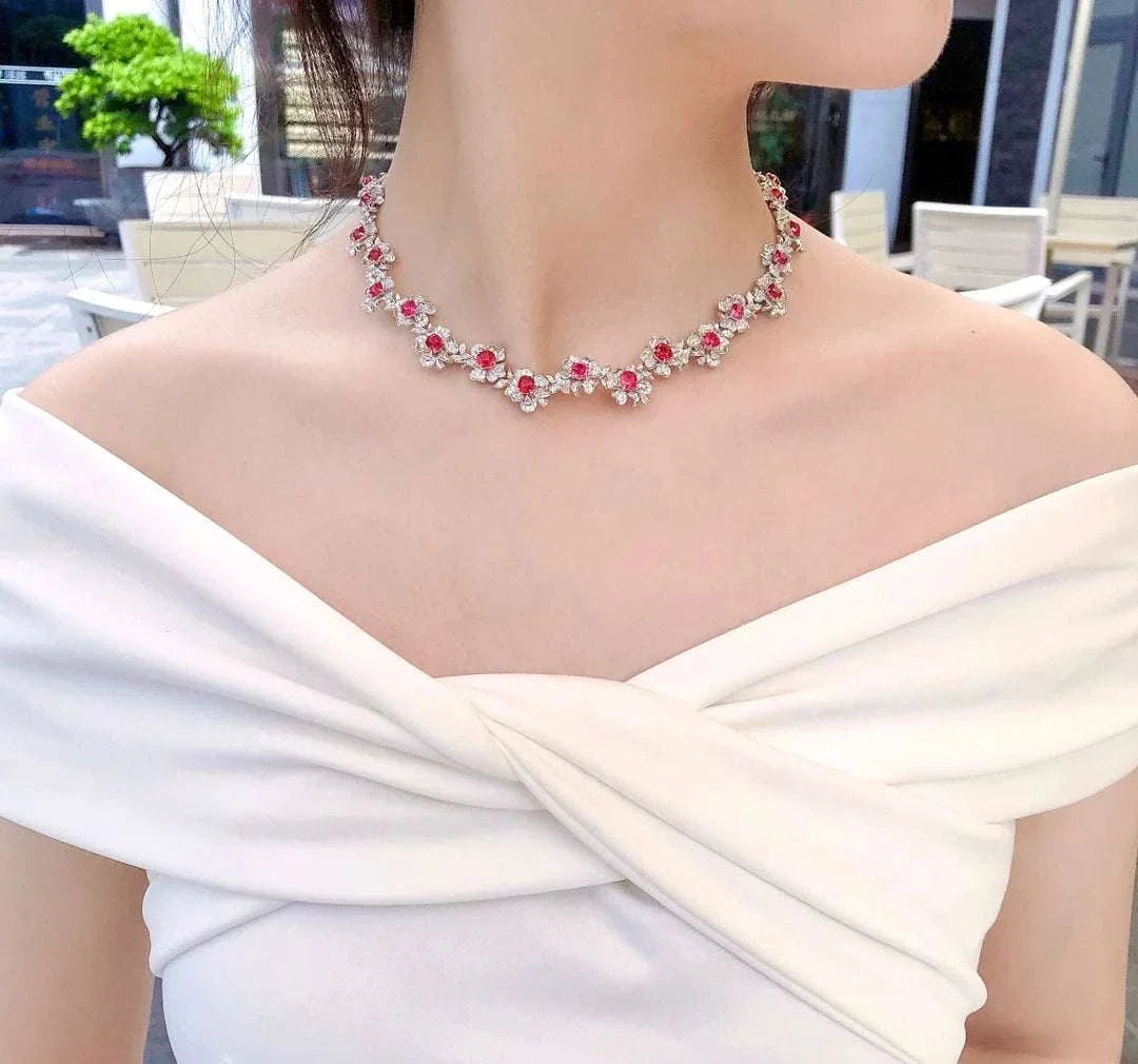 Fine jewelry solid 18K white gold necklace with natural red spinel gemstones and diamonds on woman wearing white off-shoulder dress