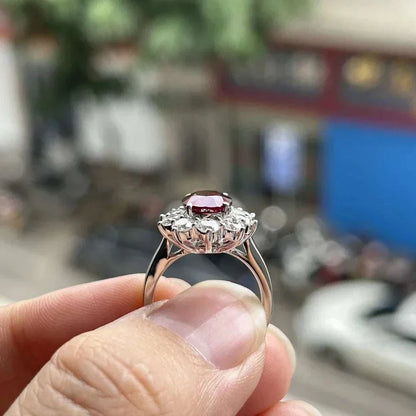 3 carat Mozambique ruby ring with diamonds in 18K white gold setting held between fingers