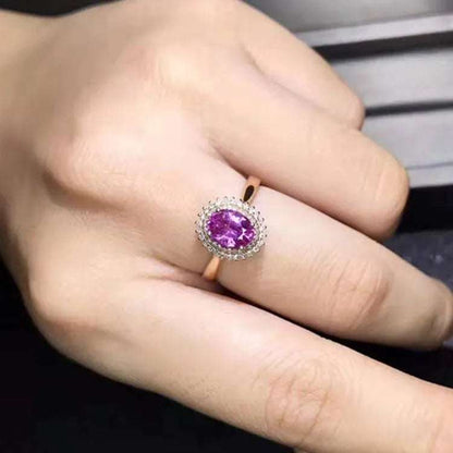 18K gold ring featuring a pink sapphire surrounded by small diamonds on a hand