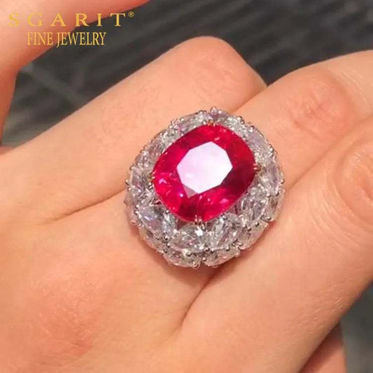 Close-up of a hand wearing the Crimson Star of Mogok 14.54ct neon red Jedi Spinel ring surrounded by sparkling diamonds.