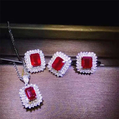 18k gold bridal set with pigeon blood rubies and diamonds, featuring necklace, earrings, and ring from the Crimson Legacy collection.
