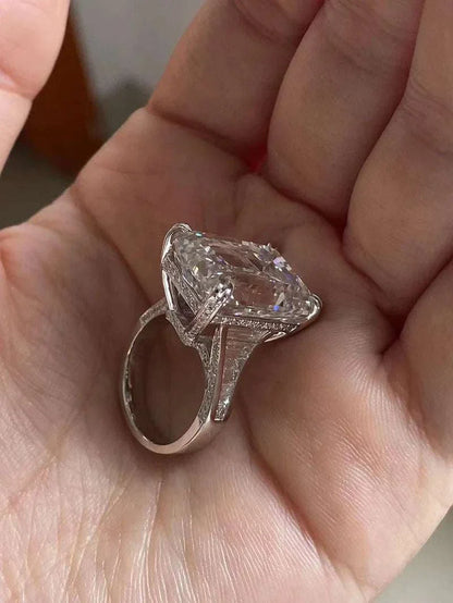 Ruif Unique Customized 20-carat emerald-cut diamond ring with intricate setting held in hand