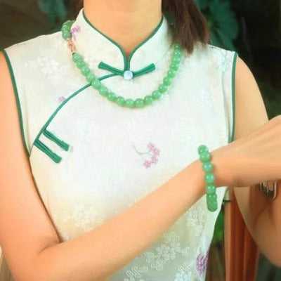 Timber’s Eye Verdant Orb necklace and bracelet made of Russian Hetian jade, worn with a floral dress.
