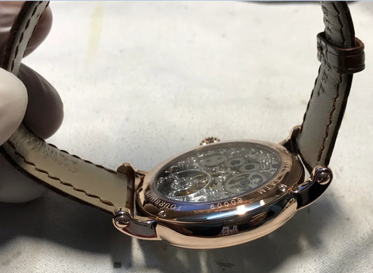 Close-up of men's automatic watch with hollow tourbillon movement and crocodile leather strap