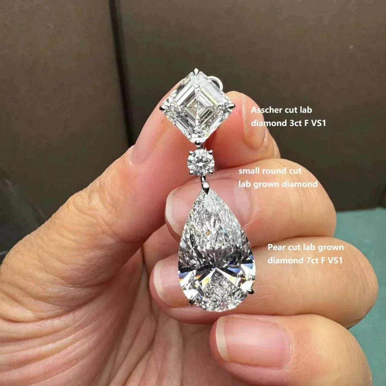Aurelia’s Radiance custom 18K gold earrings with Asscher cut 3ct, round cut, and pear cut 7ct lab-grown diamonds