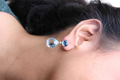 18K white gold dangle earrings with round London blue topaz, 1/5 cttw diamonds, and pear cut sky blue topaz gemstones
