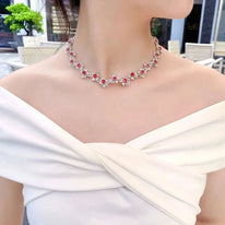 Fine jewelry solid 18K white gold necklace with natural red spinel gemstones and diamonds on woman wearing white off-shoulder dress