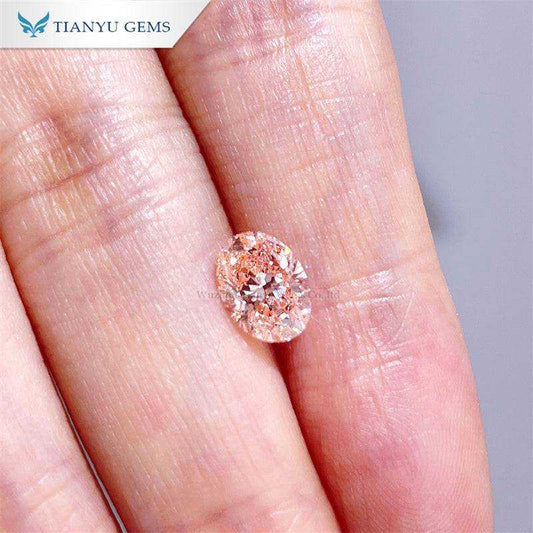 Cherry pink pear oval lab grown diamond 1.1.99ct held on fingertips by Tianyu Gems