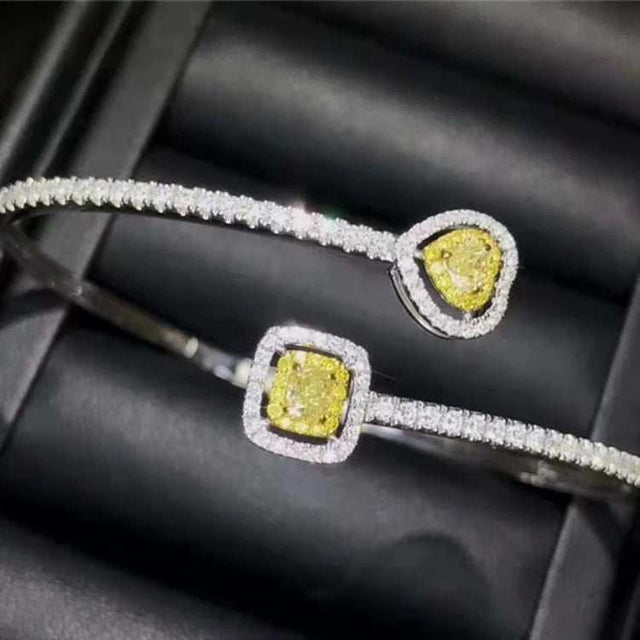 18k gold bangle bracelet with natural yellow diamond charms and surrounding white diamonds