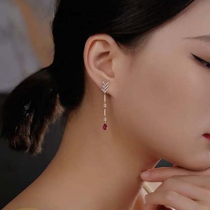 18K white gold diamond dangle earrings with white topaz and pear-shaped black onyx gemstones worn by a woman