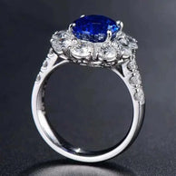 White gold ring featuring a natural blue sapphire center stone named Star of Ithil, surrounded by smaller diamonds.