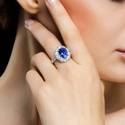 Elegant white gold ring featuring a natural blue sapphire center stone surrounded by smaller diamonds, known as the Star of Ithil ring