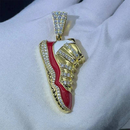Gold and red sneaker-shaped pendant encrusted with diamonds on white fabric background