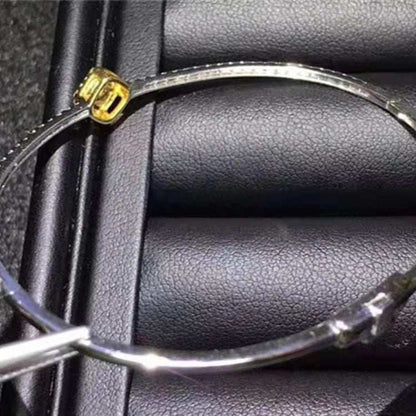 18K gold bangle featuring a 0.364ct natural yellow diamond on a black textured background
