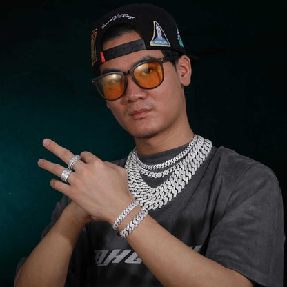 Man wearing multiple 925 sterling silver VVS moissanite Cuban link chains, bracelets, and rings with hip hop style accessories