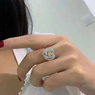 Close-up of a hand wearing a Valentine Love Serial Rose Jewelry Set diamond rose ring with gold and silver details.