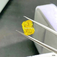 3.55 carat fancy vivid yellow Aurelion Shard lab-grown diamond held by tweezers against a neutral background