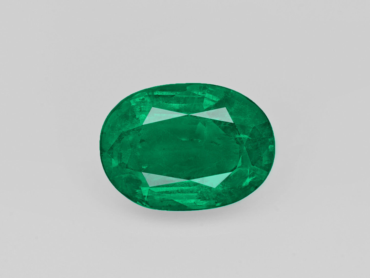 Deep green oval-shaped 5.47 carat natural Zambian emerald gemstone certified by GII