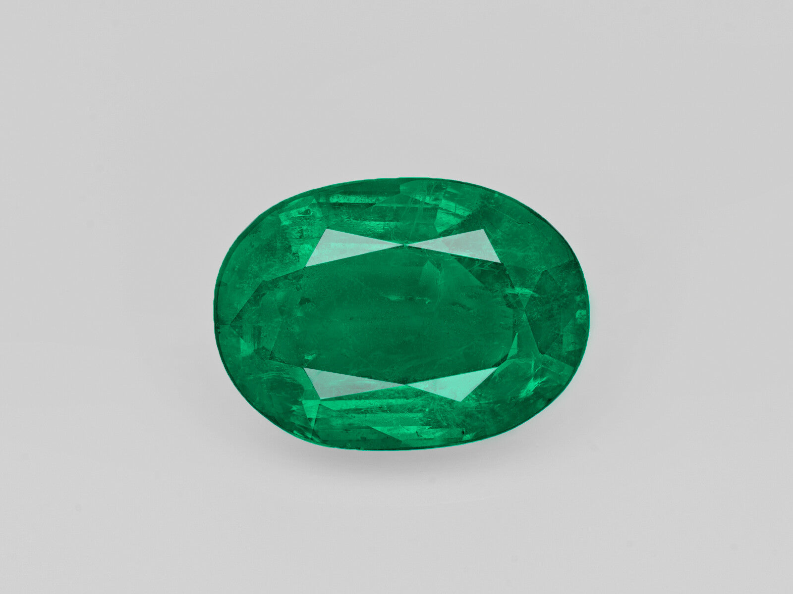Deep green oval-shaped 5.47 carat natural Zambian emerald gemstone certified by GII
